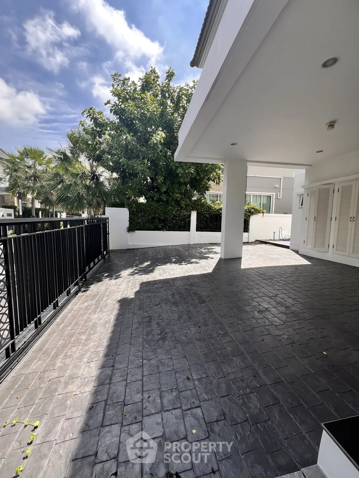 Spacious outdoor patio with modern design and lush greenery, perfect for relaxation and entertainment.
