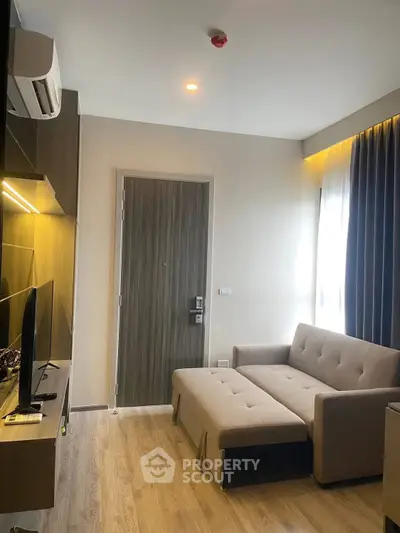 Modern living room with stylish sofa and TV unit, featuring elegant lighting and wooden flooring.