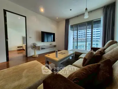 Spacious living room with modern decor and large windows offering city views.