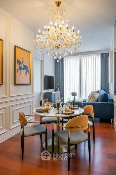 Luxurious living room with elegant chandelier and stylish dining area in modern apartment.