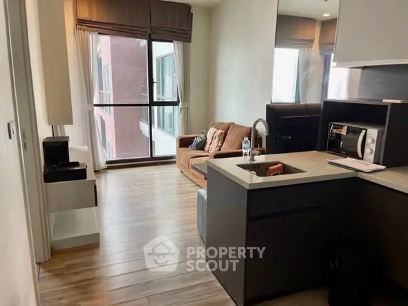 Modern apartment interior with cozy living room and kitchen area, featuring large windows and stylish decor.