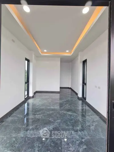 Spacious modern room with marble flooring and recessed lighting, perfect for luxury living.