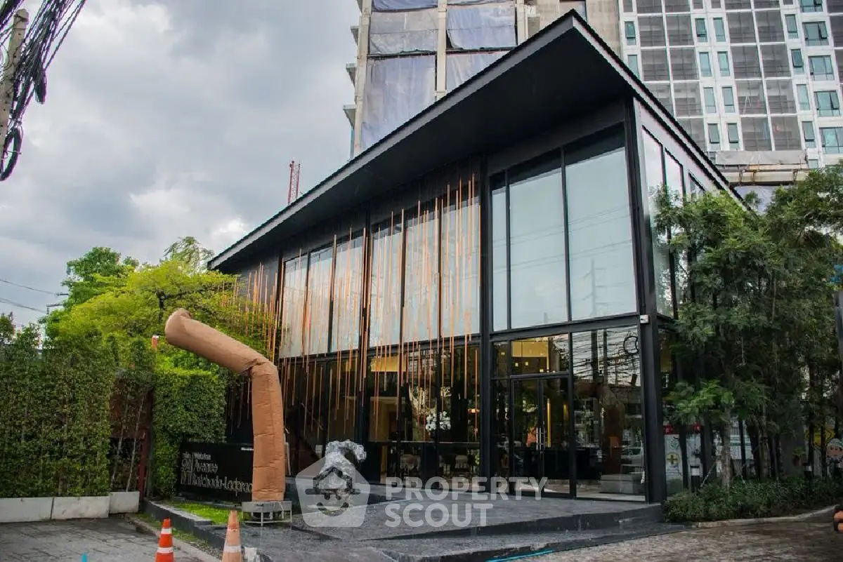 Modern architectural building with glass facade and lush greenery, ideal for urban living.