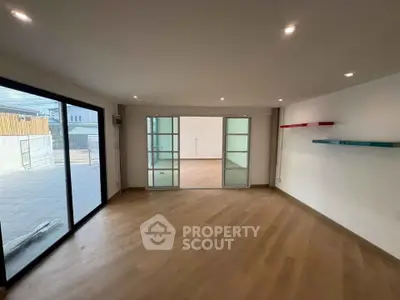 Spacious modern living room with sliding glass doors and wooden flooring
