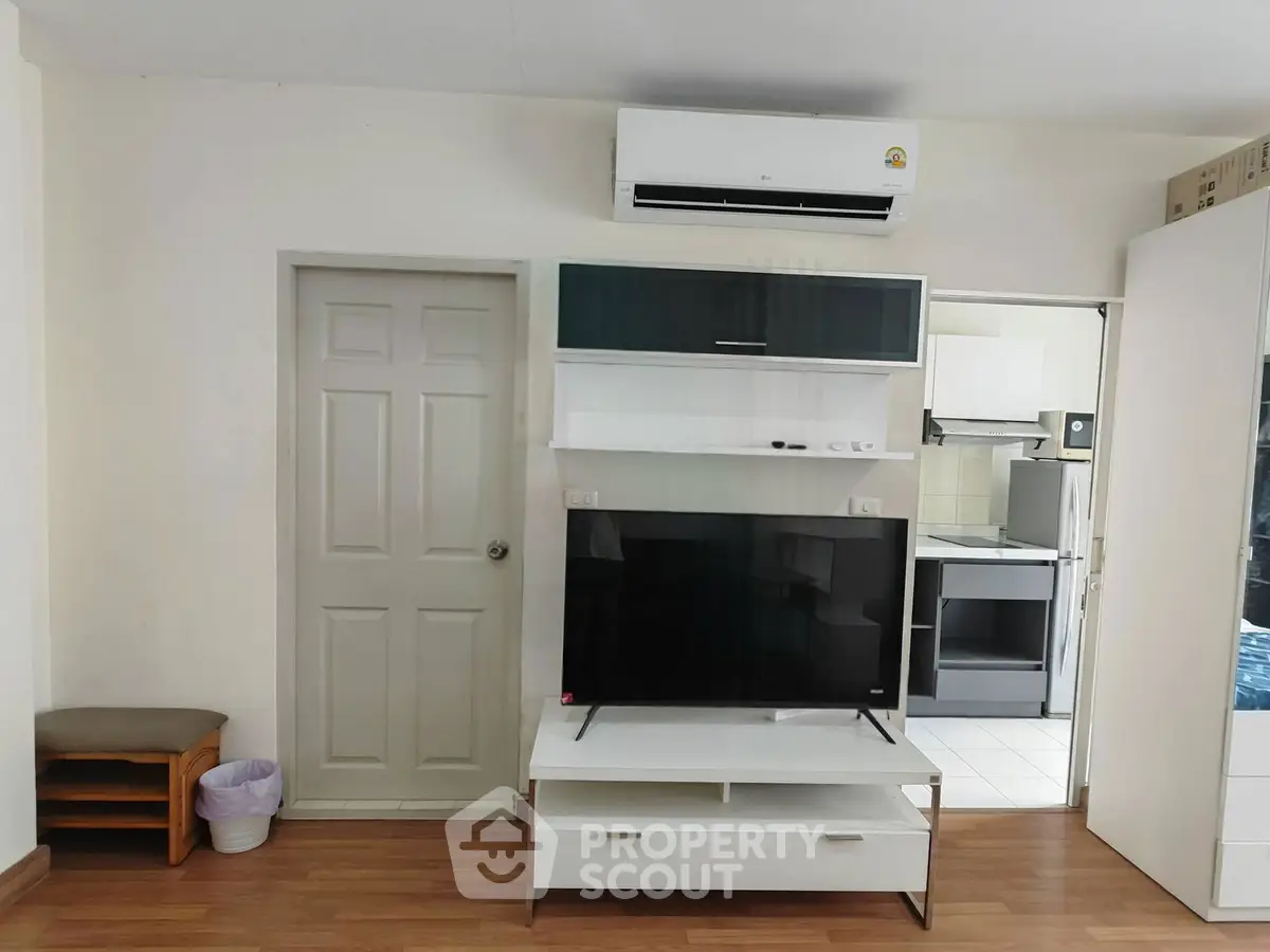 Modern living room with sleek TV unit and air conditioning, showcasing contemporary design and comfort.