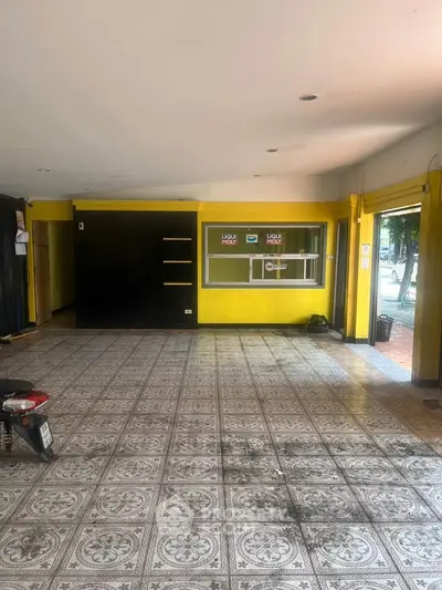 Spacious commercial space with tiled flooring and large windows for natural light.