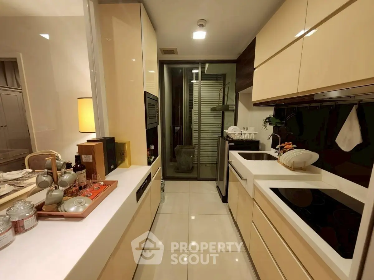 Modern kitchen with sleek cabinetry and built-in appliances, featuring a cozy dining area and elegant lighting.