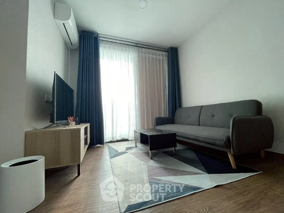 Modern living room with stylish furniture and large window, perfect for relaxation.