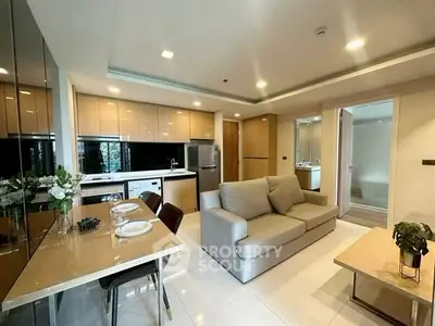 Modern open-layout living room and kitchen with sleek design and cozy ambiance.