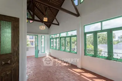 Stunning sunlit balcony with rustic charm and lush garden views