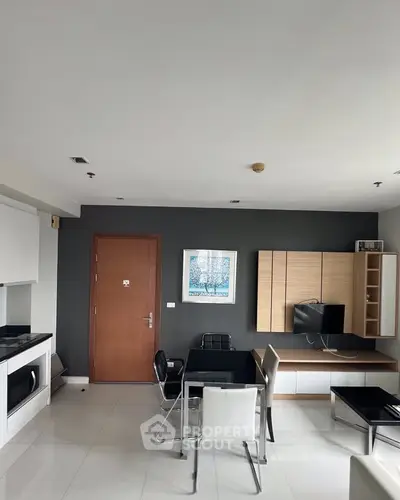 Modern living room with sleek furniture and integrated kitchen in a stylish apartment.