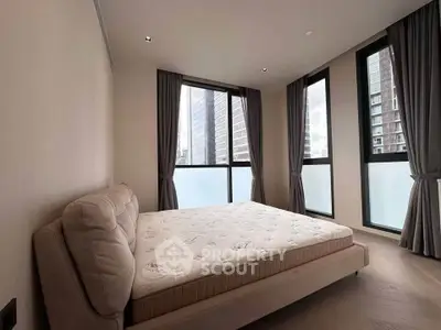Spacious bedroom with large windows offering city views in modern apartment