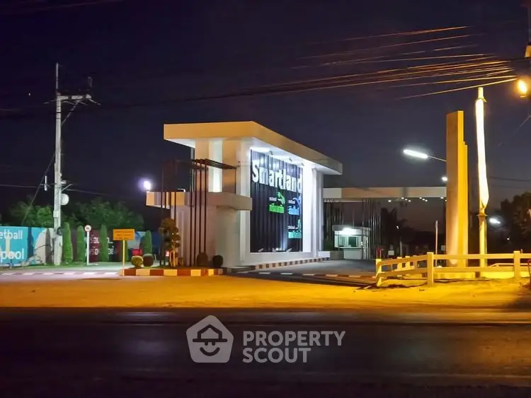 Modern real estate entrance at night with illuminated signage and sleek design.
