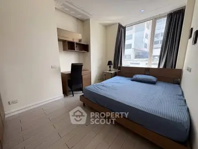 Modern bedroom with large window and study desk in urban apartment