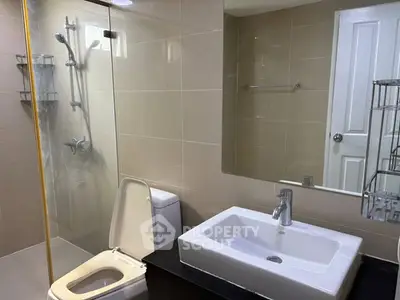 Modern bathroom with sleek fixtures and glass shower enclosure in a contemporary home.