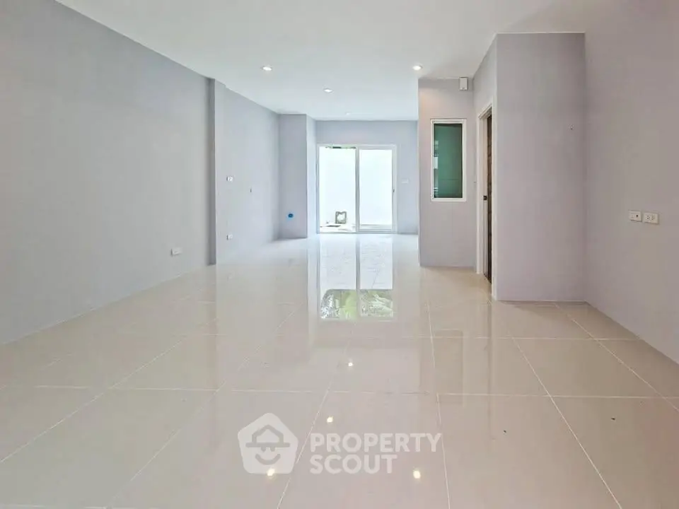 Spacious empty living room with glossy tiled floors and modern design