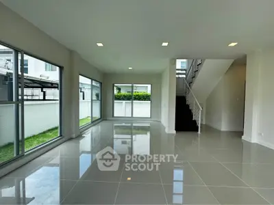Spacious modern living room with large windows and glossy tile flooring