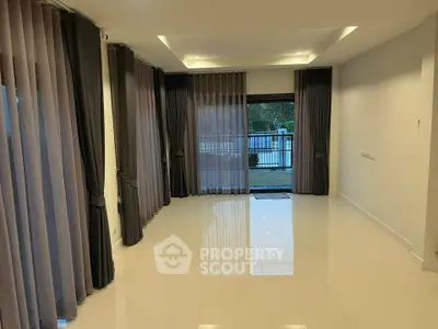 Spacious modern living room with elegant floor-to-ceiling curtains and glossy tile flooring.