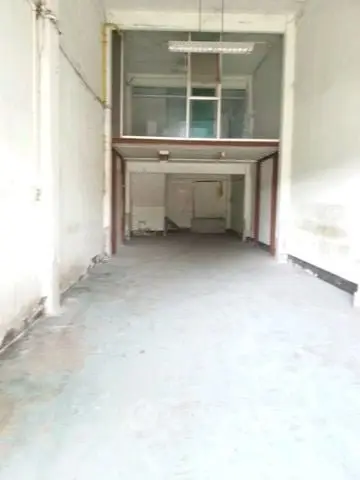 Spacious industrial unit with high ceilings and mezzanine level, ideal for storage or workshop use.