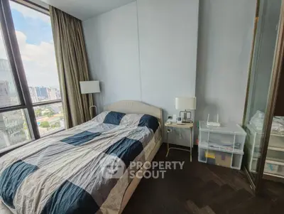 Modern bedroom with city view, featuring a cozy bed and stylish decor, perfect for urban living.