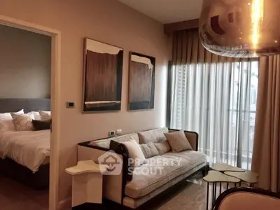 Stylish modern living room with cozy sofa and elegant decor next to a bright bedroom.