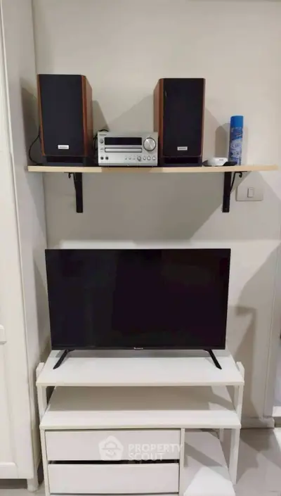 Modern living room setup with TV and sound system on sleek shelves.