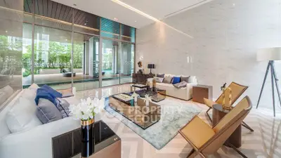 Luxurious modern living room with elegant decor and large windows overlooking greenery.