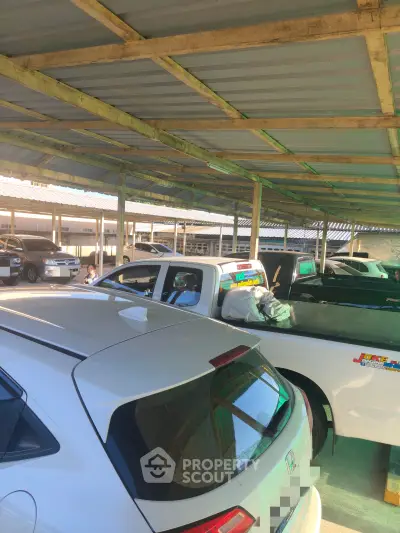 Covered parking area with multiple vehicles in a residential or commercial property.