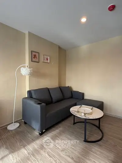Cozy living room with modern gray sofa and stylish round coffee table, perfect for relaxation.