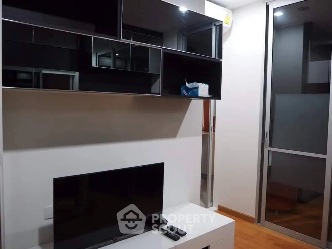 Modern living room with sleek TV setup and stylish storage cabinets.