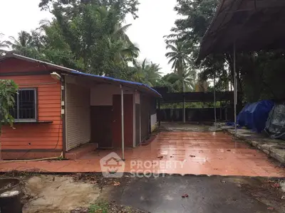 Charming rustic exterior with spacious tiled patio and lush greenery.