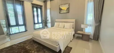 Luxurious bedroom with modern decor and large windows in a stylish home.