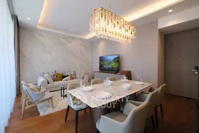 Luxurious open-plan living and dining area with elegant chandelier and modern decor.
