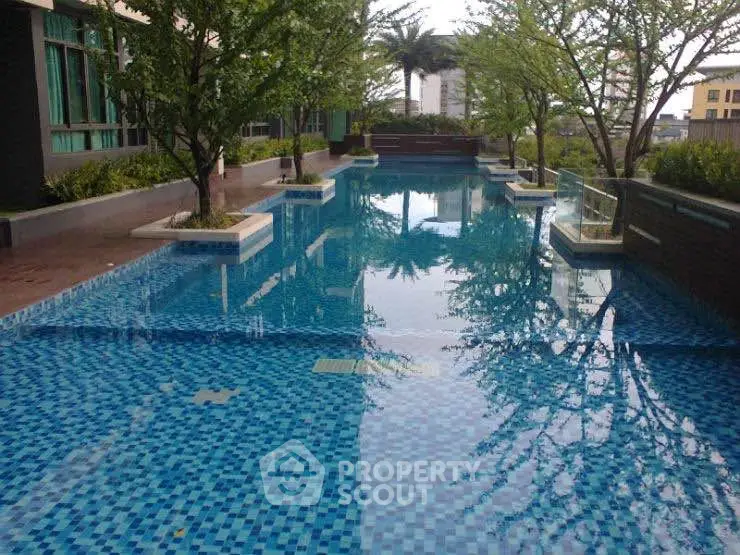 Luxurious residential pool area with lush greenery and modern design.