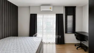 Modern minimalist bedroom with large window and stylish black curtains