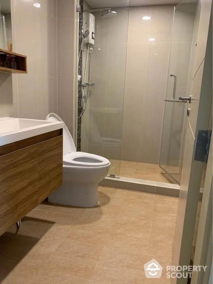 Modern bathroom with glass shower and sleek wooden vanity