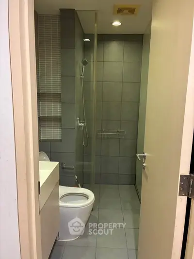 Modern bathroom with sleek design and glass shower enclosure in a contemporary apartment.