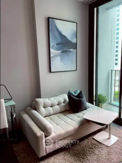 Stylish modern living room with cozy sofa and elegant decor near a balcony with city view.
