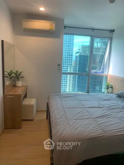 Modern bedroom with city view, featuring sleek furniture and natural light.