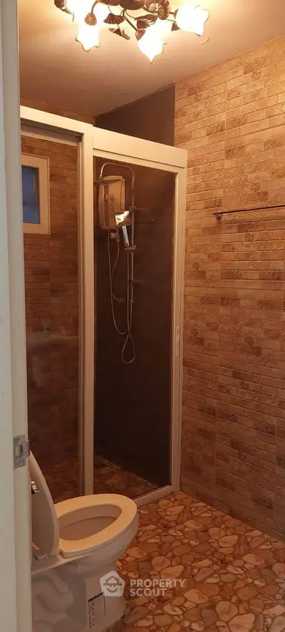Modern bathroom with stone tile walls and enclosed shower