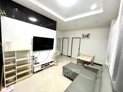 Modern living room with sleek design, featuring a wall-mounted TV and stylish furniture.