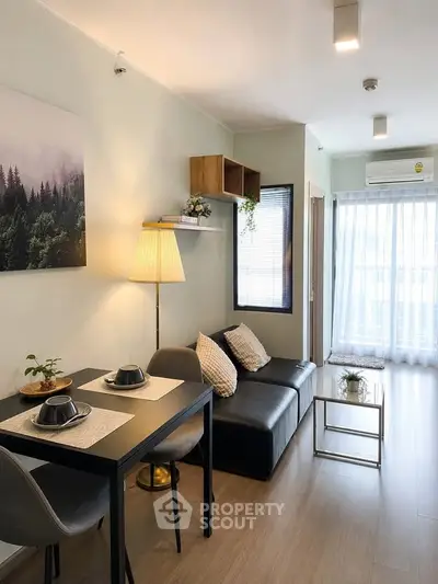 Modern living room with cozy seating and dining area, featuring stylish decor and natural light.