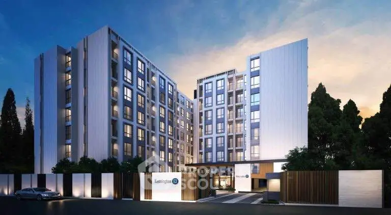 Modern apartment building exterior with sleek design and evening lighting.