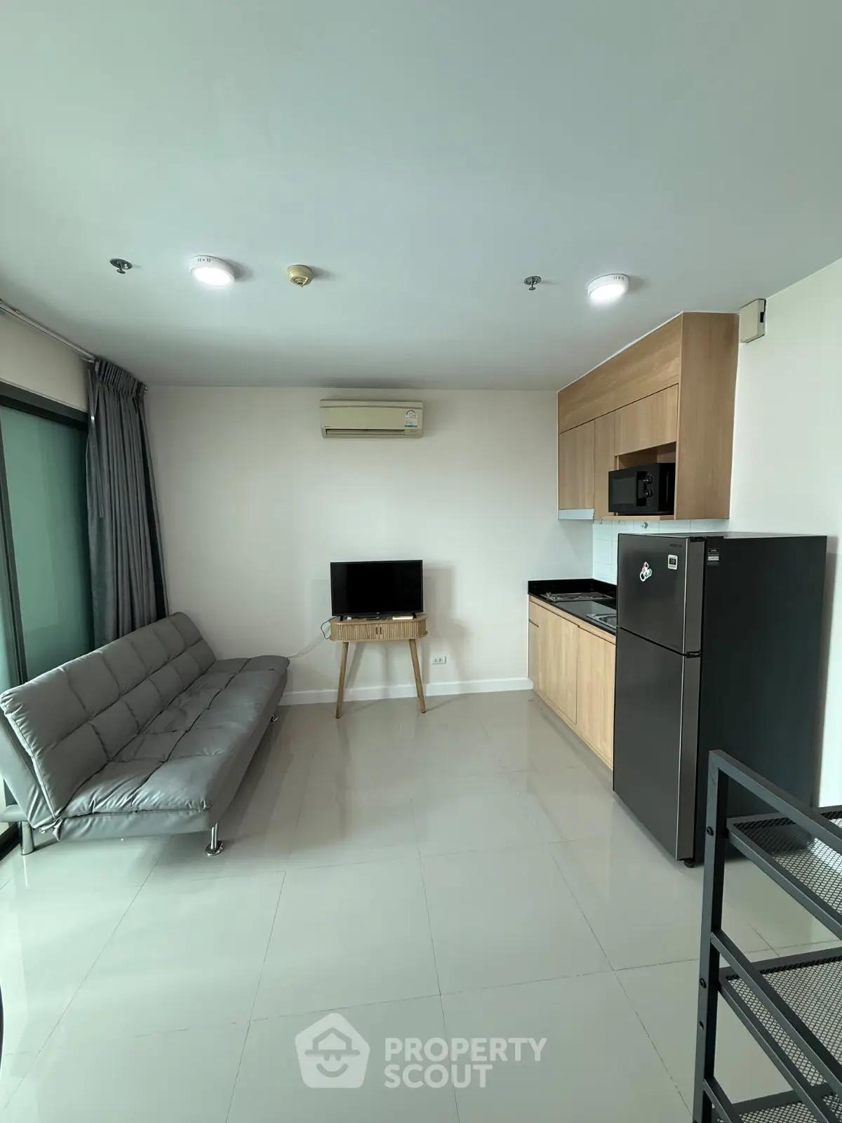 Modern living room with sleek kitchen and stylish furniture in a contemporary apartment.
