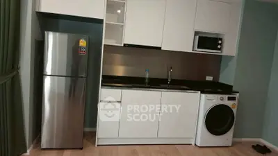 Modern kitchen with sleek appliances including fridge, microwave, and washing machine in stylish apartment.