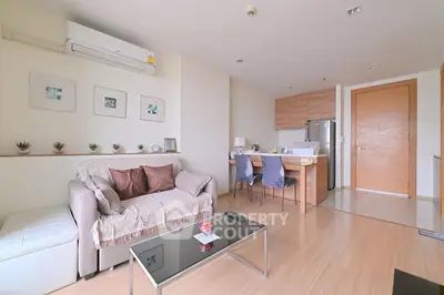 Modern living room with cozy sofa and dining area in open layout apartment.