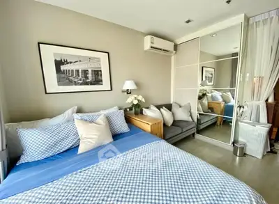 Cozy bedroom with modern decor, featuring a large bed, mirrored wardrobe, and stylish artwork.