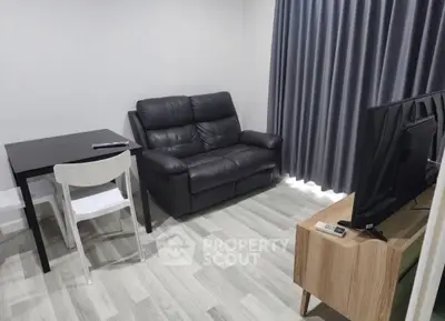 Modern living room with sleek furniture and flat-screen TV, perfect for relaxation.