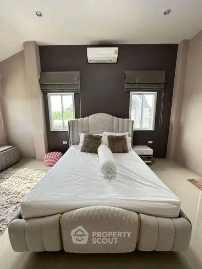 Luxurious bedroom with elegant bed and modern decor, featuring large windows and plush furnishings.