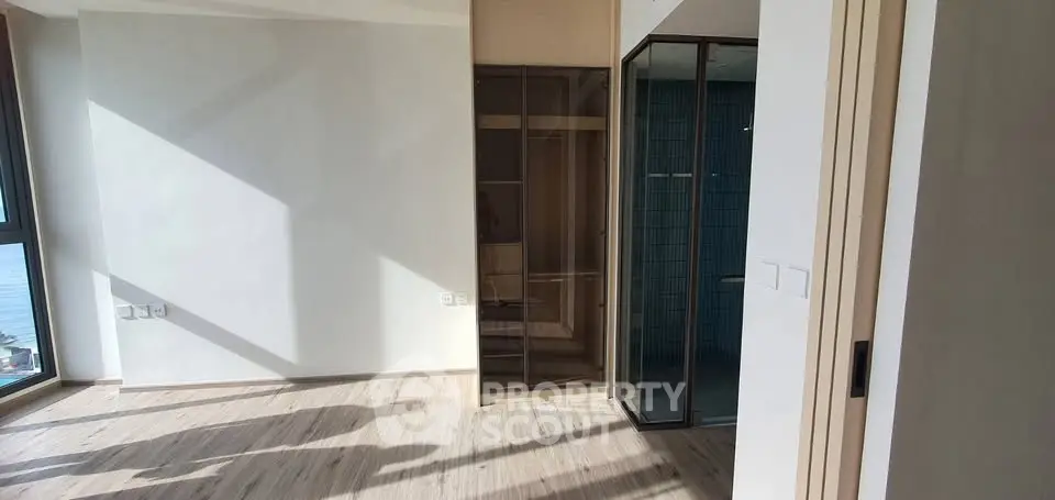 Bright modern living room with large windows and wooden flooring, offering a serene ocean view.